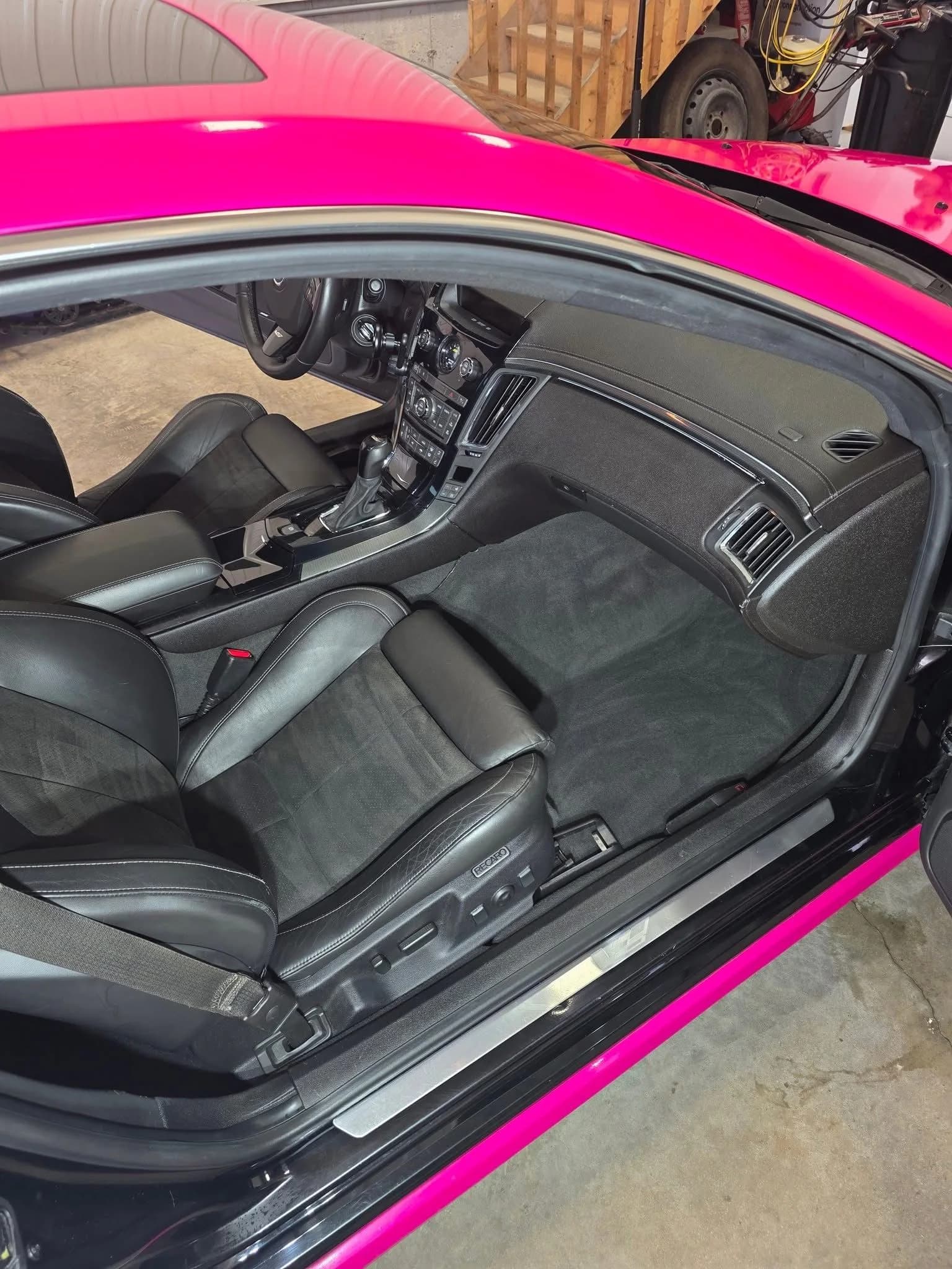 Habitacle noir et sièges en cuir d’une Cadillac rose