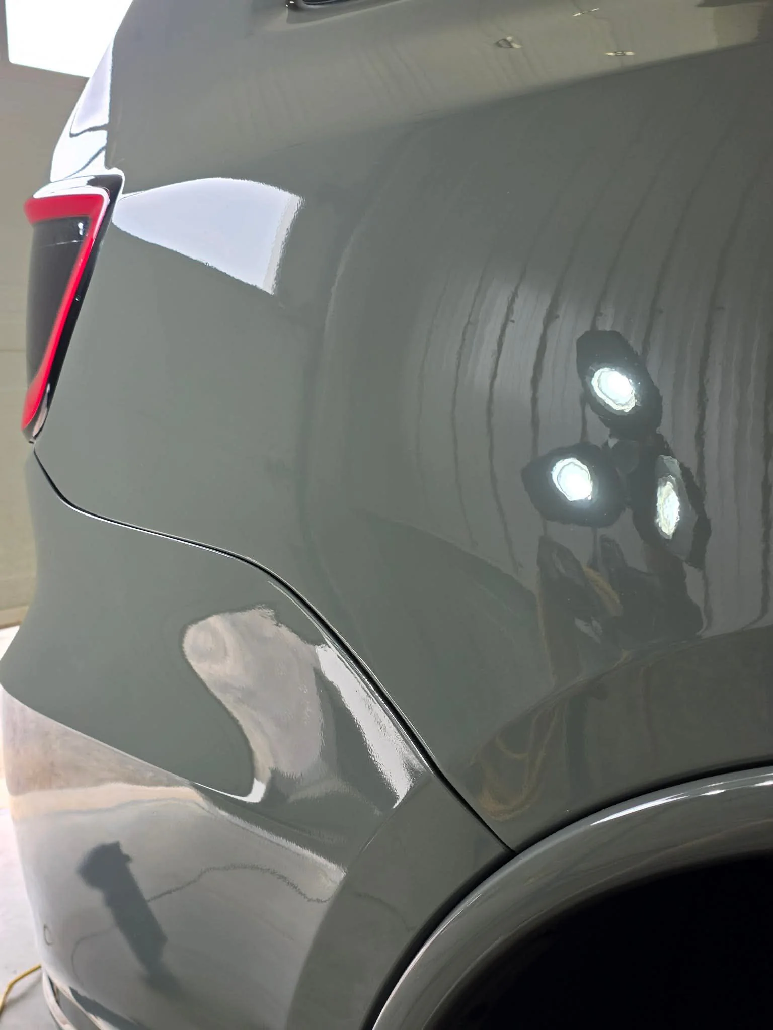 Reflets de lampes de contrôle sur un panneau de carrosserie gris