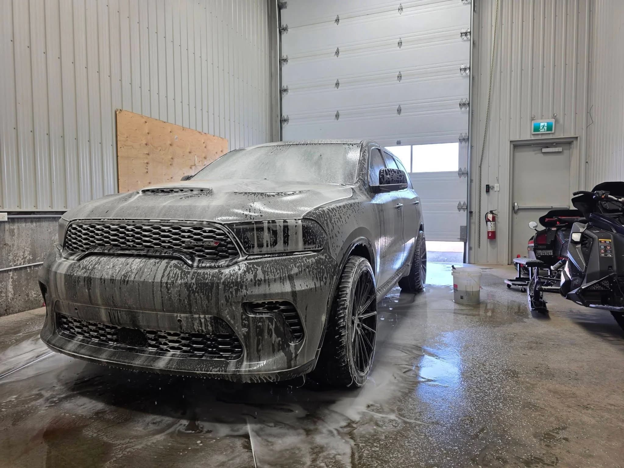 Dodge Durango gris couvert de mousse pendant la préparation