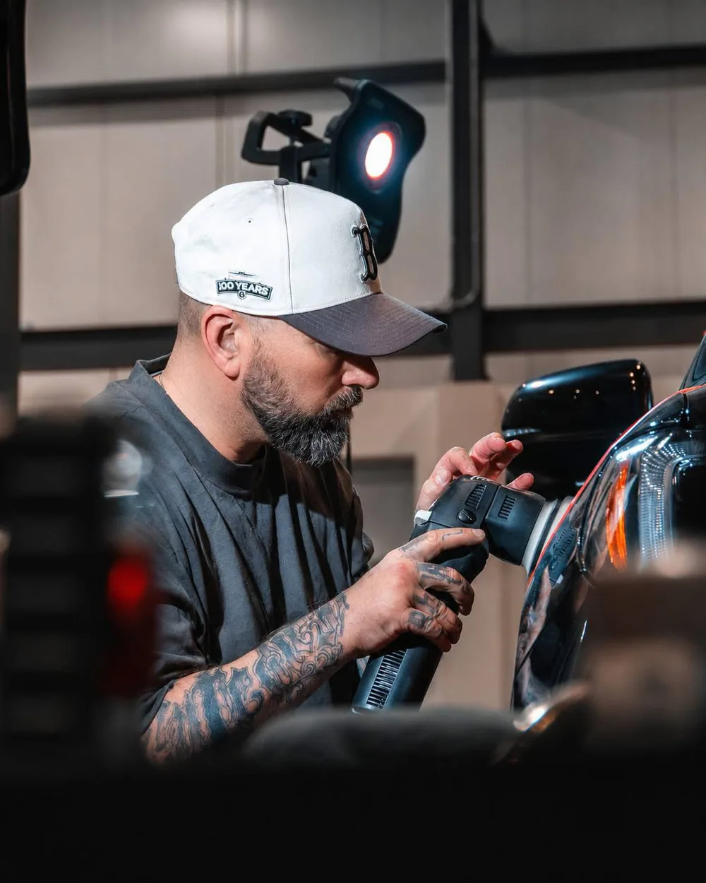 Frédéric concentré sur le polissage d’un véhicule à l’atelier